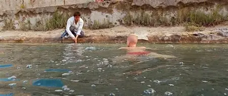 هش تربية فتاة تسبح في نهر مع الثدي العارية