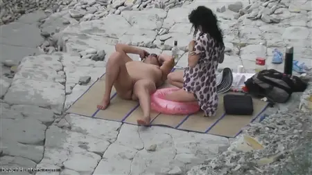 صديقات عاهرة مع ثدي عاريات تسترخي على شاطئ مهجور